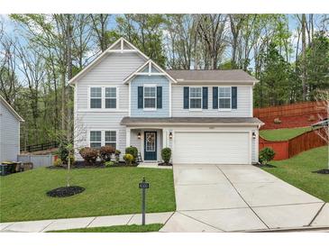 Charming two-story home with a well-manicured lawn and a two-car garage, showcasing curb appeal at 6350 Lantana Village Way, Cumming, GA 30028