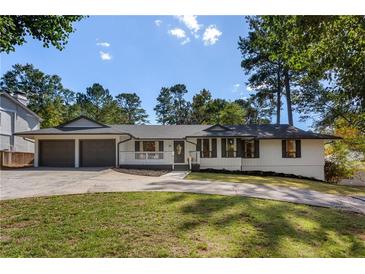 Charming ranch home featuring a well-manicured lawn and a two-car garage at 1025 Martins Lake Close, Roswell, GA 30076