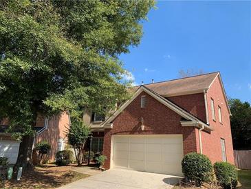 Charming two-story brick home with an attached two-car garage and mature landscaping in a suburban neighborhood at 3259 S Pointe Ct, Atlanta, GA 30340