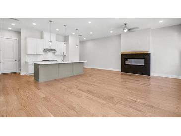 Spacious living room with hardwood floors, a modern fireplace, and open to the kitchen at 2572 Silver Star Ne Dr, Marietta, GA 30066