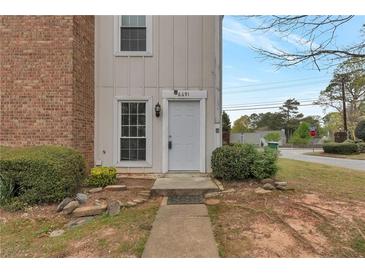 Inviting townhouse featuring a light gray front door and manicured landscaping at 6691 Colchester Pl, Norcross, GA 30093