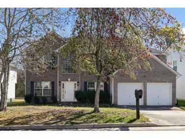 Charming two-story brick home with an attached two-car garage and mature landscaping at 1640 Rice Sq, Lithonia, GA 30058