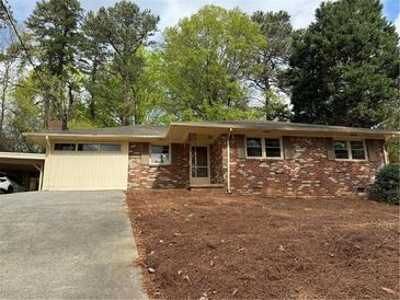 Charming brick ranch home with a carport and well-maintained front yard at 3712 Spring Hill Se Rd, Smyrna, GA 30080