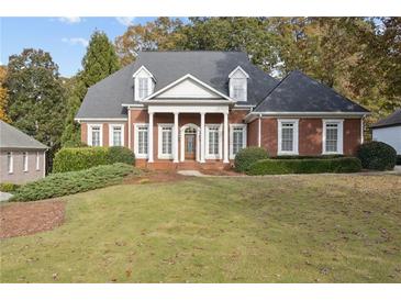 Inviting two-story brick home featuring a symmetrical facade, stately columns, and a well-manicured lawn at 4385 Old Hamilton Mill Rd, Buford, GA 30518