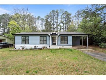 Charming light blue one-story home with well-manicured lawn and covered carport at 1601 Sycamore Nw Dr, Kennesaw, GA 30152