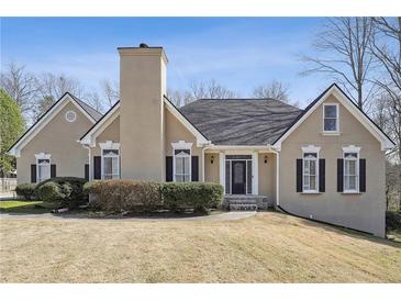 Charming home featuring a neutral color palette, black shutters, chimney, and well-manicured landscaping at 2973 Heavenly Ln, Snellville, GA 30078