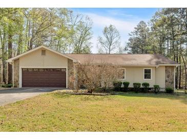 Charming single-story home featuring a two-car garage and a well-maintained front lawn at 4670 Sundridge Trl, Fairburn, GA 30213