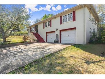 Charming two-story home with white brick, red trim, a two-car garage, and a concrete driveway at 945 Blackwell Rd, Marietta, GA 30066