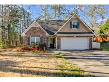 Charming brick home with a well-maintained front yard and attached two-car garage at 8166 N Pine Cone Dr, Villa Rica, GA 30180