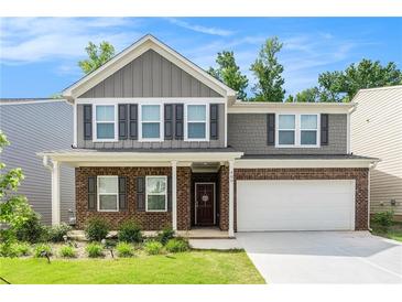 Charming two-story home with a brick facade, gray siding, and a well-manicured front lawn at 400 Paulownia Cir, Mcdonough, GA 30253