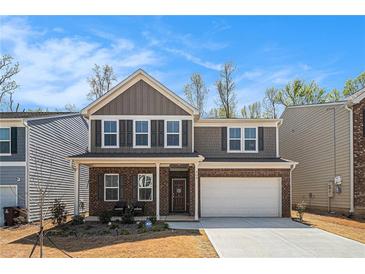 Charming two-story home with a brick facade, attached garage, and well-manicured lawn and beautiful blue sky at 400 Paulownia Cir, Mcdonough, GA 30253