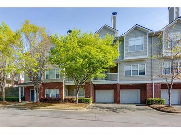 Charming multi-story townhouse with brick accents and manicured landscaping at 8020 Woodland Ln, Alpharetta, GA 30009
