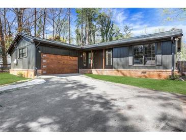 Charming one-story home featuring a wooden garage door and a well-maintained front yard at 3650 Dogwood Farm Rd, Decatur, GA 30034