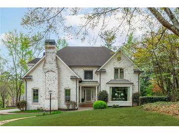 Stunning two-story home with a brick facade, well-manicured lawn, and mature trees creating a picturesque curb appeal at 730 Denmead Se Ml, Marietta, GA 30067