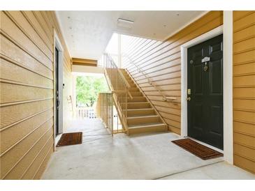 Building exterior featuring wood siding, staircase and entry doors with welcome mats at 225 Bentley Pl, Tucker, GA 30084