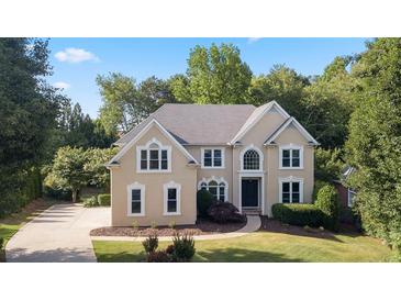 Charming two-story home with a well-manicured lawn and mature trees offers great curb appeal at 915 Summer Wind Pl, Roswell, GA 30075