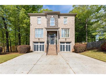 Traditional two-story brick home featuring a two-car garage and professionally landscaped front yard at 3110 Dickson Ne St, Brookhaven, GA 30319