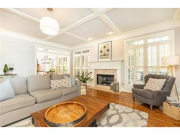 Bright living room featuring a fireplace, hardwood floors, plantation shutters, coffered ceiling, and stylish decor at 3110 Dickson Ne St, Brookhaven, GA 30319