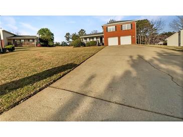 Two-story red brick house with a two-car garage and a large front yard at 5211 Benjamin Trl, Ellenwood, GA 30294