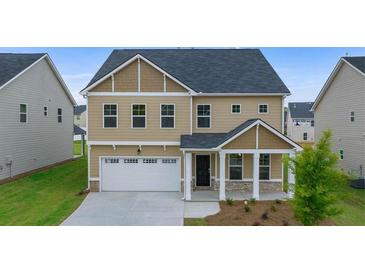 Charming two-story home with a welcoming front porch and a two-car garage at 13562 Whitman Ln, Covington, GA 30014