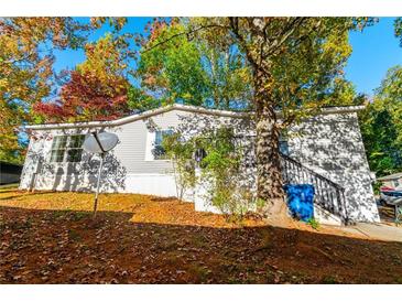 Charming single-story home with gray siding, mature trees, and a well-maintained front yard at 7024 Evergreen Way, Buford, GA 30518