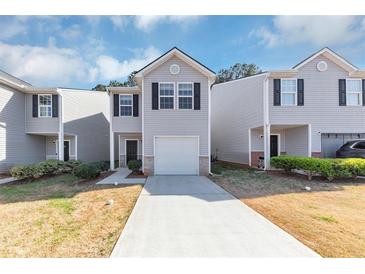 Charming townhome featuring a one-car garage and neutral siding at 222 Alton Cir, Villa Rica, GA 30180