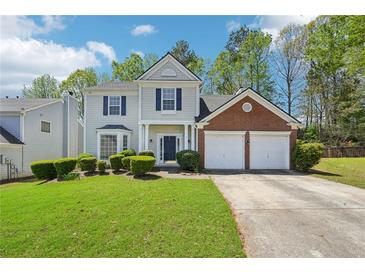Charming two-story home features a two-car garage, manicured lawn, and classic architectural details at 3936 Toccoa Falls Dr, Duluth, GA 30097