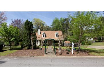 Charming home featuring a landscaped front yard, sidewalk, and mature trees at 728 Slew Ave, Lawrenceville, GA 30043