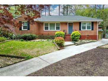 Charming brick home with a well-manicured front yard and a quaint blue front door at 1245 Briar Hills Ne Dr, Atlanta, GA 30306