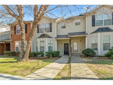 Charming townhome with a well-manicured lawn, sidewalk, and inviting entrance, nestled in a desirable neighborhood at 127 Hawkeye Ln, Conyers, GA 30012