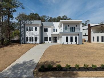 Stunning modern home featuring a contemporary design with a long driveway and landscaped front yard at 4031 Oak Forest Cir, Marietta, GA 30062