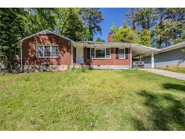 Charming brick home featuring a carport, well-maintained lawn, and mature trees at 1239 Avonwood Sw Cir, Atlanta, GA 30311