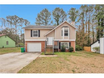 Charming two-story home with a brick and siding exterior, front yard, and attached garage at 2463 Corner Shoals Dr, Decatur, GA 30034