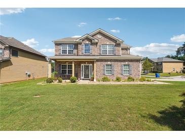 Charming two-story brick home featuring a well-manicured front yard and inviting curb appeal at 7514 Absinth Dr Pass, Atlanta, GA 30349