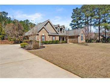 Charming brick home featuring manicured lawn, mature trees, and an extended driveway at 79 Tiffany Trce, Palmetto, GA 30268