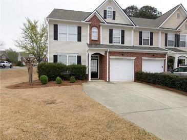 Inviting townhome featuring a brick facade, attached garage, and well-maintained landscaping at 3615 Hutchinson Trace Dr, Cumming, GA 30040