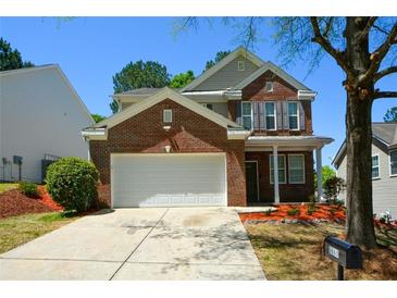 Inviting two-story brick home with a two-car garage and manicured landscaping at 5660 Sable Bay Pt, Atlanta, GA 30349