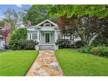 Charming home featuring a stone walkway leading to the covered porch and manicured lawn at 638 Cooledge Ne Ave, Atlanta, GA 30306