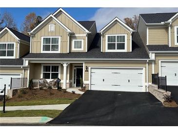 Charming townhome showcasing well-manicured landscaping, attached garage, and inviting entrance at 2702 Wollerton St # 2702, Cumming, GA 30040