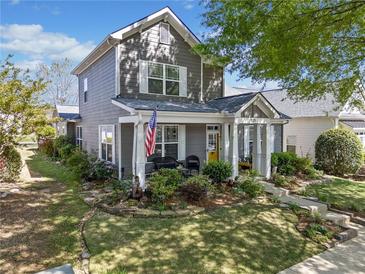 Charming two-story home with a manicured lawn and inviting front porch, featuring a yellow front door at 429 Argonne Ter, Canton, GA 30115