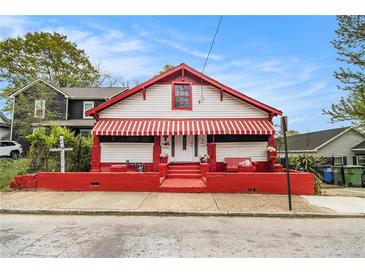 Charming home with white and red exterior, awning, and landscaped front yard at 814 Welch Sw St, Atlanta, GA 30310