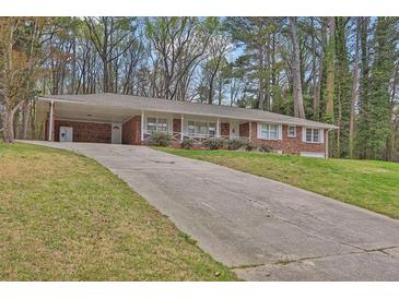 Charming one-story brick home featuring a covered front porch, a long driveway, and mature trees at 3441 Palace Ct, Tucker, GA 30084
