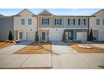 Modern townhome exterior featuring a mix of neutral siding and a concrete driveway at 7083 Gladstone Cir, Stonecrest, GA 30038