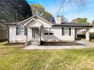 Charming single-story home featuring white siding, black shutters, covered carport, and inviting front entrance at 1886 Hazelwood Se Dr, Marietta, GA 30067