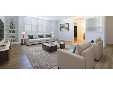 Bright living room with built-in bookshelves, neutral furniture, and a decorative area rug at 2965 Pharr Court South Nw # 503, Atlanta, GA 30305