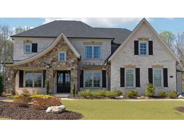 Charming two-story home with brick and stone accents, black shutters, manicured lawn and landscape in the front yard at 3515 Montebello Pkwy, Cumming, GA 30028