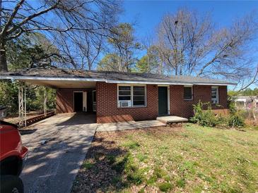 Red brick single-story home with a covered carport and small front yard at 103 Woodhaven Dr, Stockbridge, GA 30281
