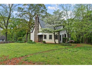 Charming cottage-style home with stone chimney and lush front yard at 2601 Semmes St, Atlanta, GA 30344
