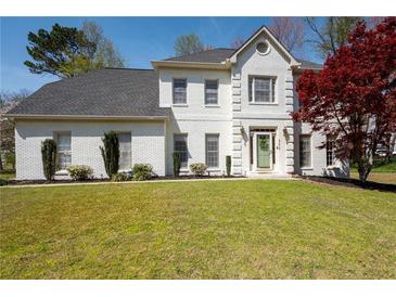 Charming two-story white brick home with a well-manicured lawn and a welcoming green front door at 966 Laurel Springs Sw Ln, Marietta, GA 30064