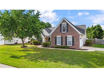 Well-manicured lawn and landscaping accent this charming brick two-story home with black shutters at 2650 Hamilton Chase Run, Buford, GA 30519